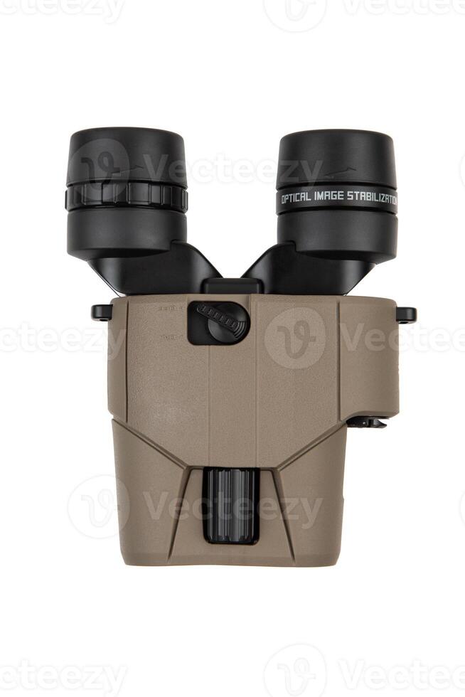 Compact binoculars with a tan body and black eyepieces, featuring image stabilization technology, isolated on a white background. photo