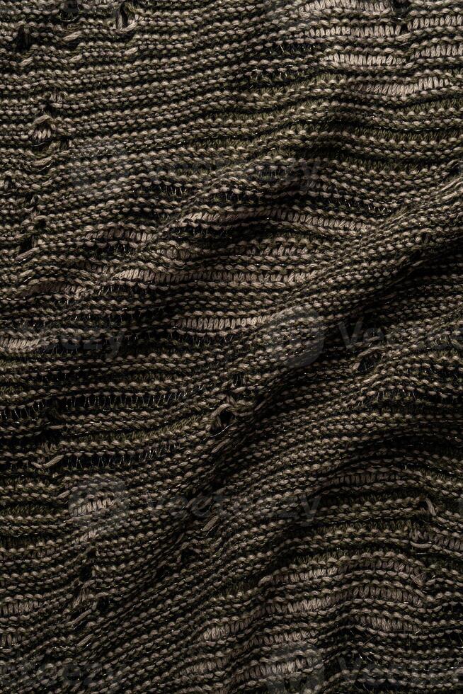 A close-up view of intricately woven fabric, blending dark and light threads to form a detailed pattern. Ideal for textile design projects. photo