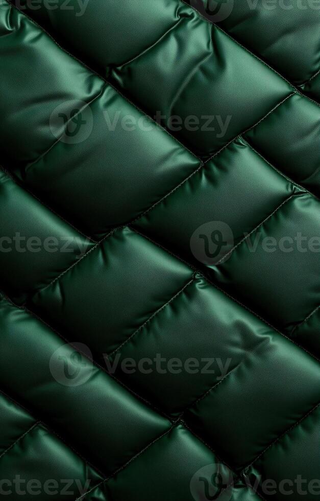 Green quilted fabric, close-up, showing detailed stitching and a soft, padded texture. photo