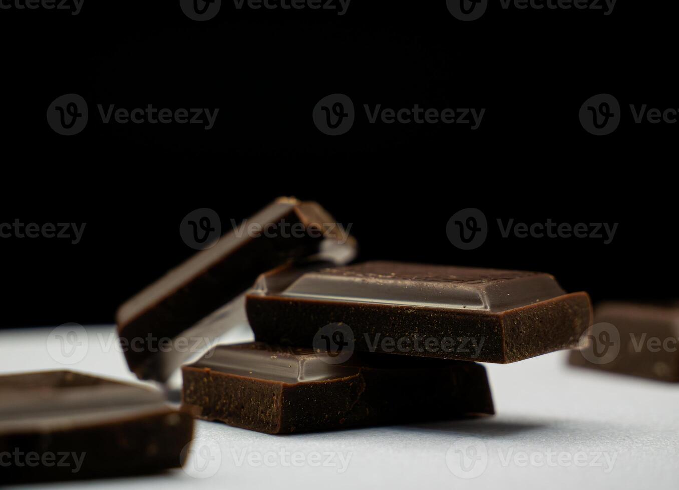 Stack of Dark Chocolate Squares on a Dark Background Close-Up shot photo