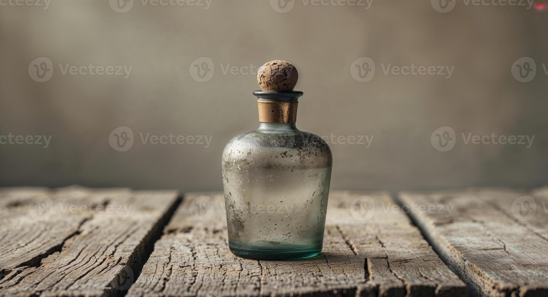 An old glass bottle with a wooden stopper on a wooden table photo