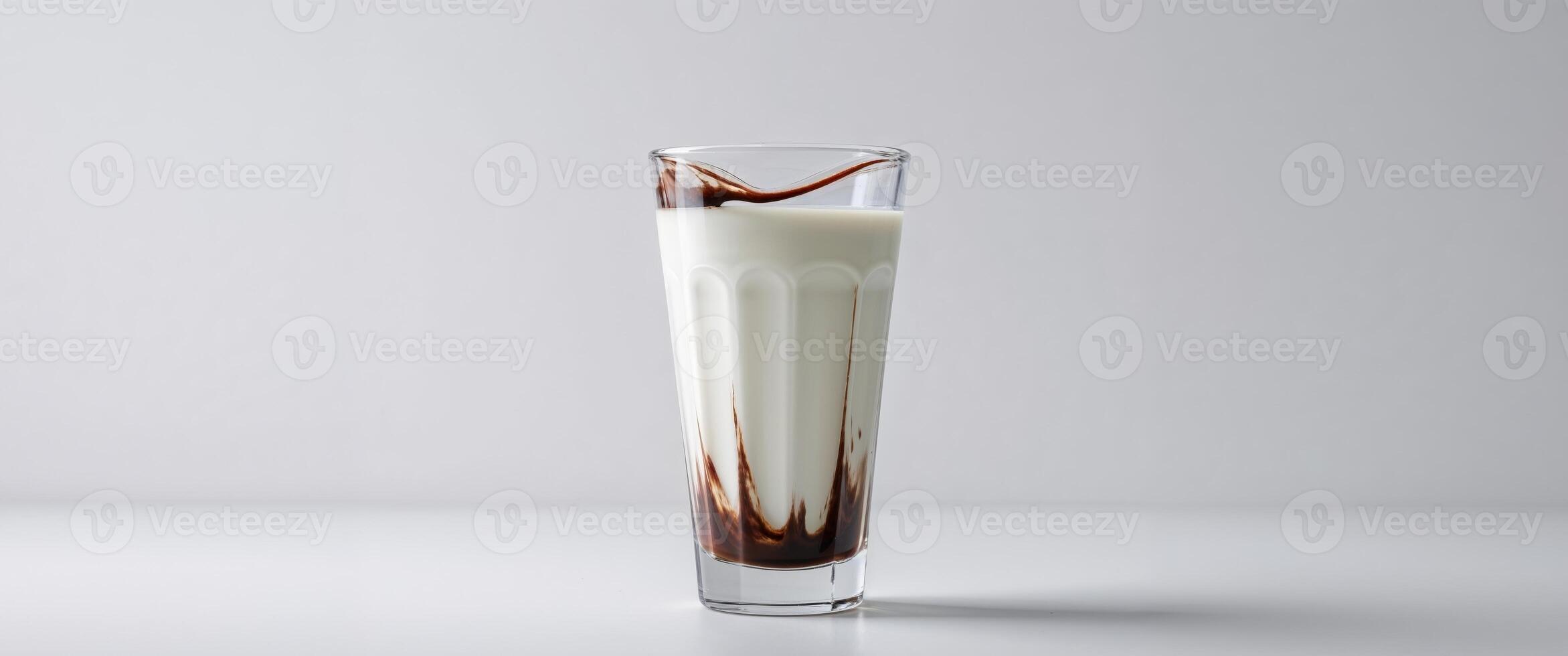 A glass of milk with chocolate drizzled on top photo