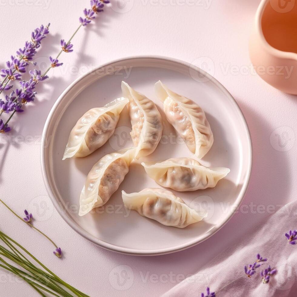 Pork and cabbage dumplings arranged on a plate with lavender and soft fabric accents photo