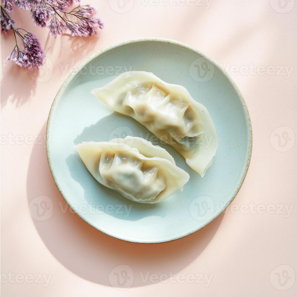 Artfully cut open cabbage and pork dumplings displayed on a minimalist plate with delicate flowers photo