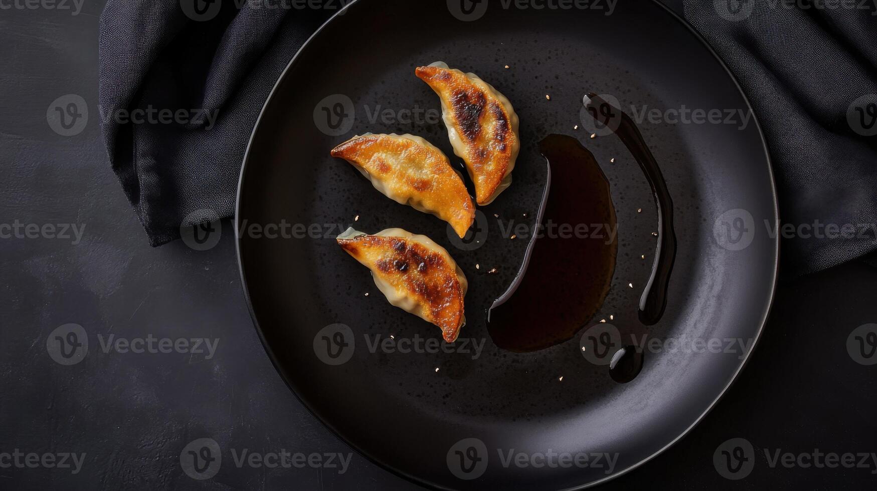 Delicious dumplings served with soy sauce on a black plate for an appetizing presentation photo