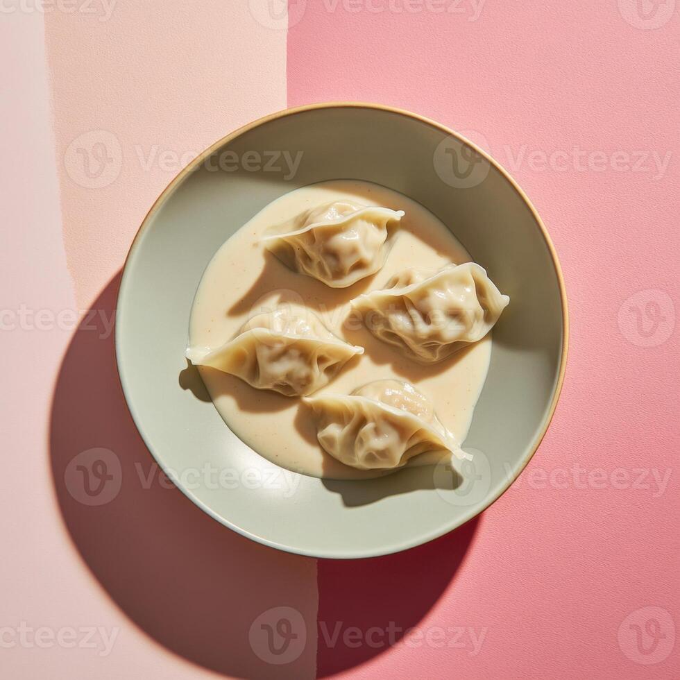 Delicious dumplings in creamy sauce beautifully arranged on a pastel plate photo