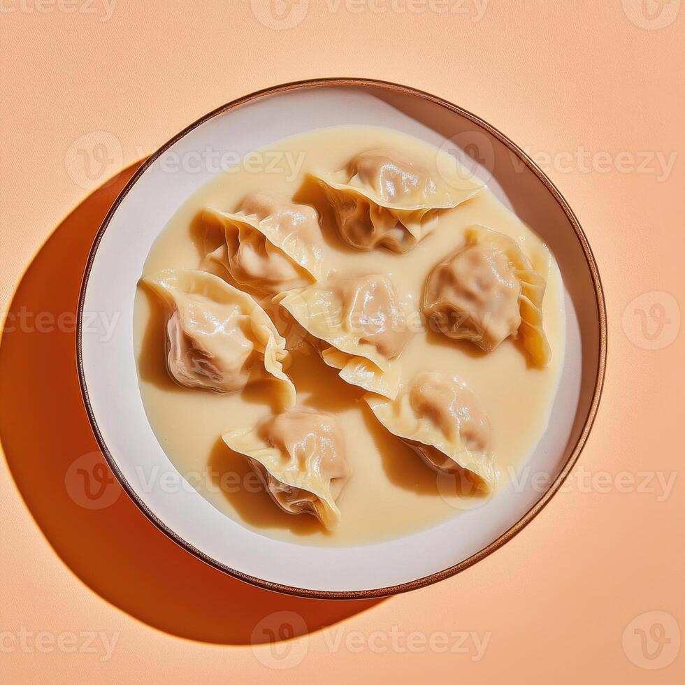 Dumplings served in creamy sauce create a visually appealing culinary experience on a textured plate photo