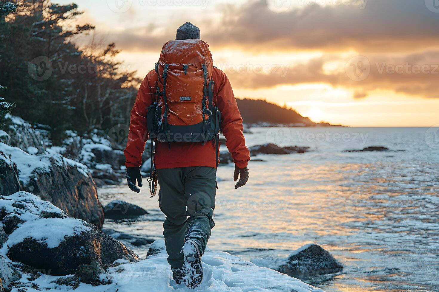 Winter Adventure Solo Hiker on Snow-Covered Lakeside Trail at Sunrise photo