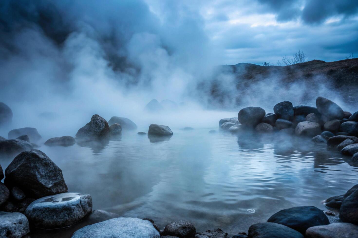 Serene Misty Hot Springs Landscape with Smooth Rocks and Cloudy Sky photo