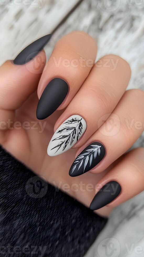 Elegant black and white nail design featuring intricate leaf patterns on a stylish background photo