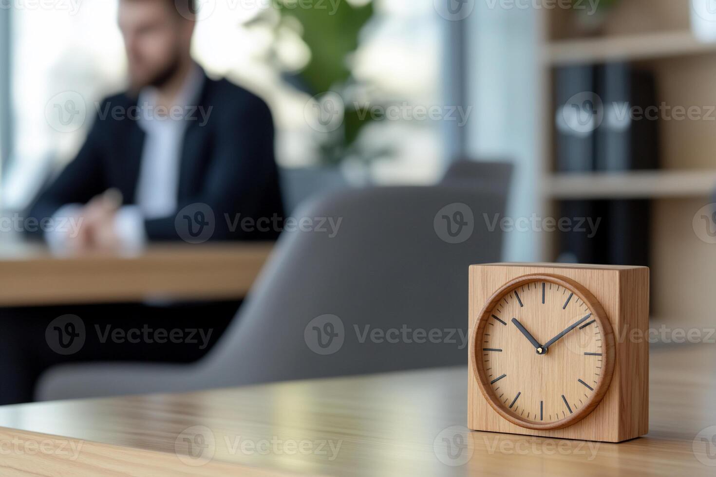 Wooden clock on office desk, blurred business man background photo
