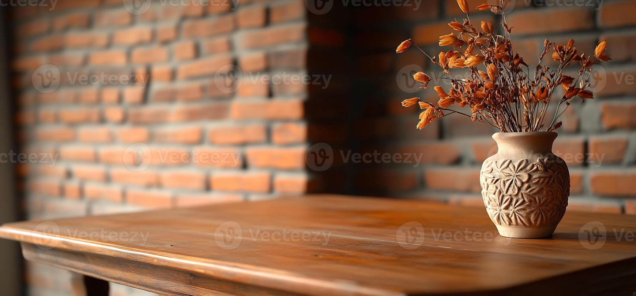 Dried flowers in vase on wooden table, brick wall background, home decor photo