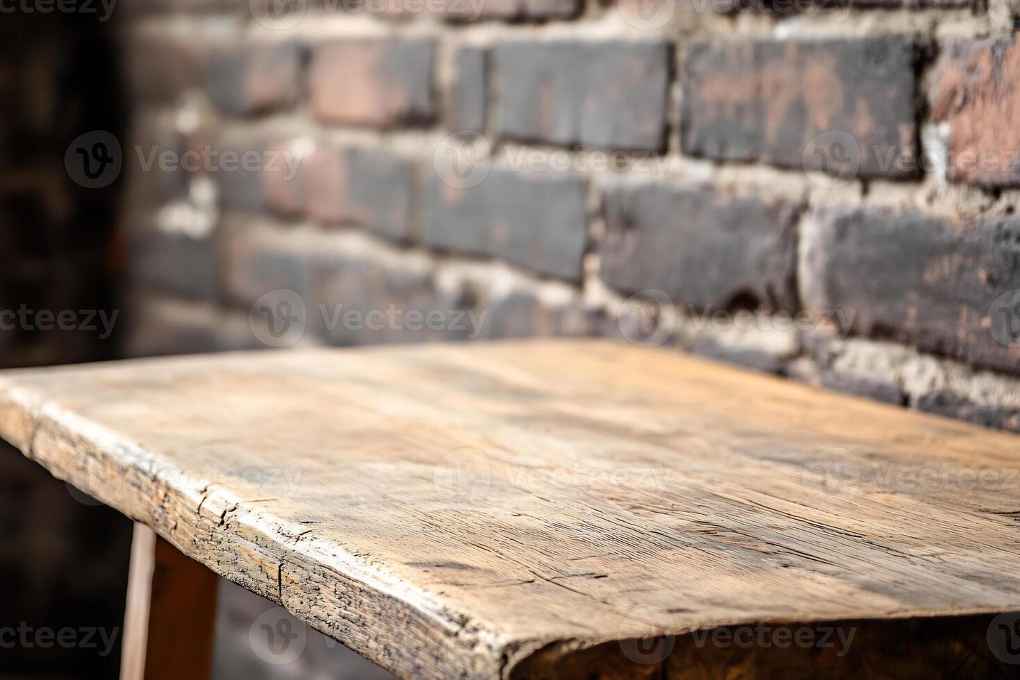 Empty wooden table against brick wall photo
