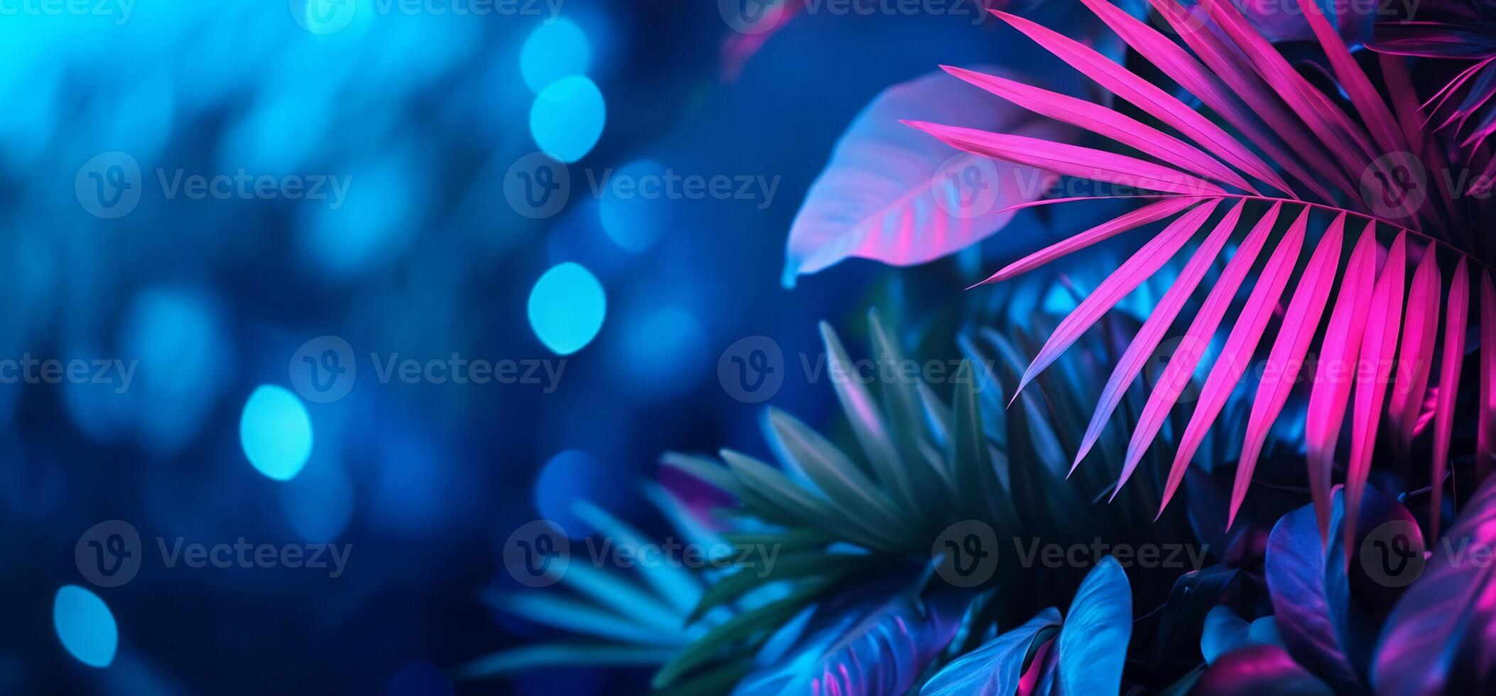 Neon-lit tropical leaves and bokeh background. photo