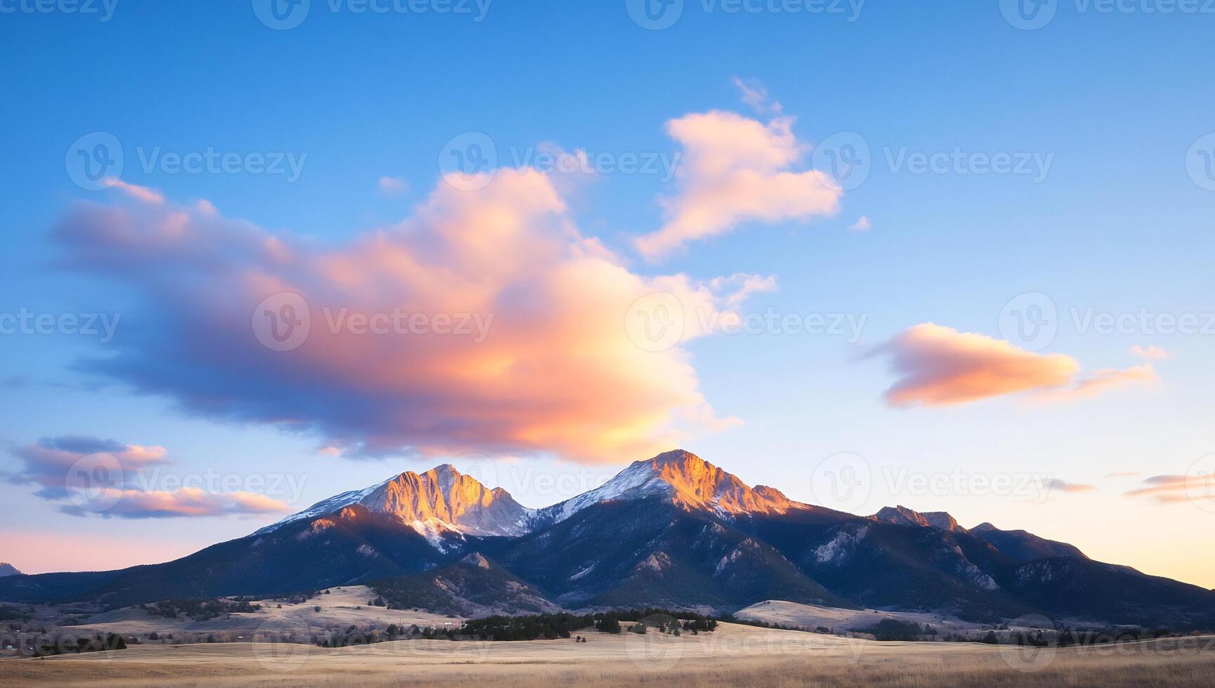 Sunset over snow-capped mountains with a vibrant pink cloud. photo