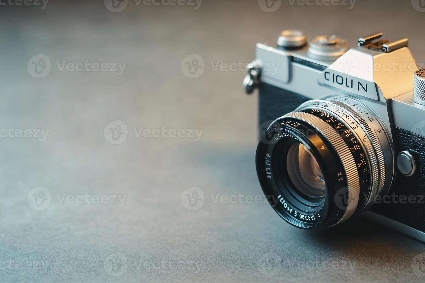 Close-up of vintage silver camera on gray surface. photo