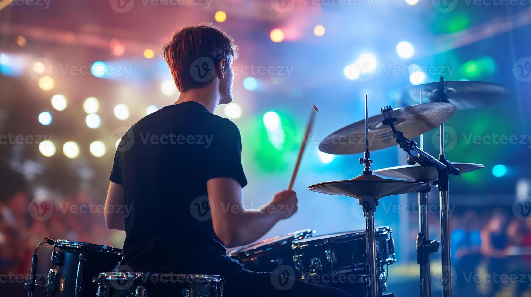 A drummer playing on stage at a concert photo