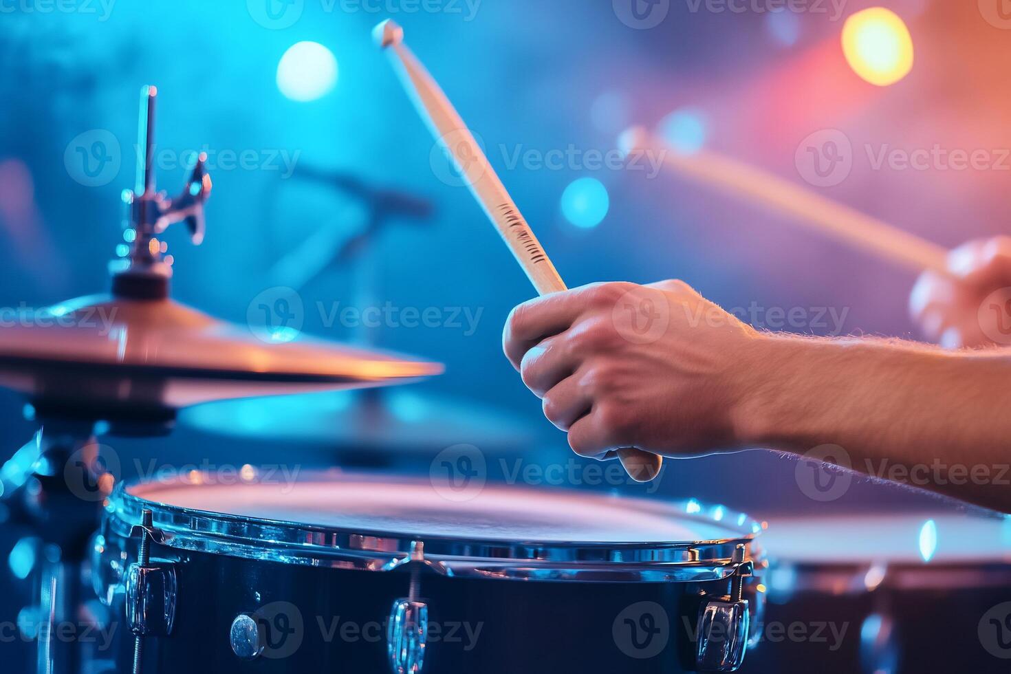 Close-up of drummer's hands playing drums on stage with colorful lights. photo