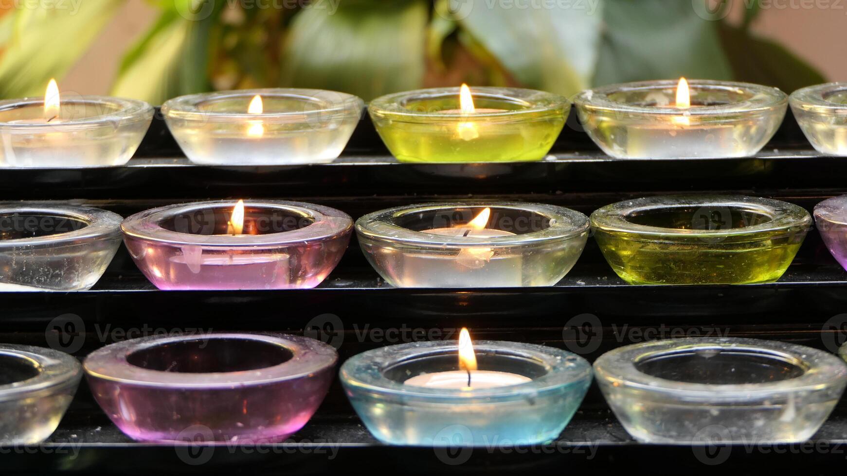 a row of candles with different colors lit photo