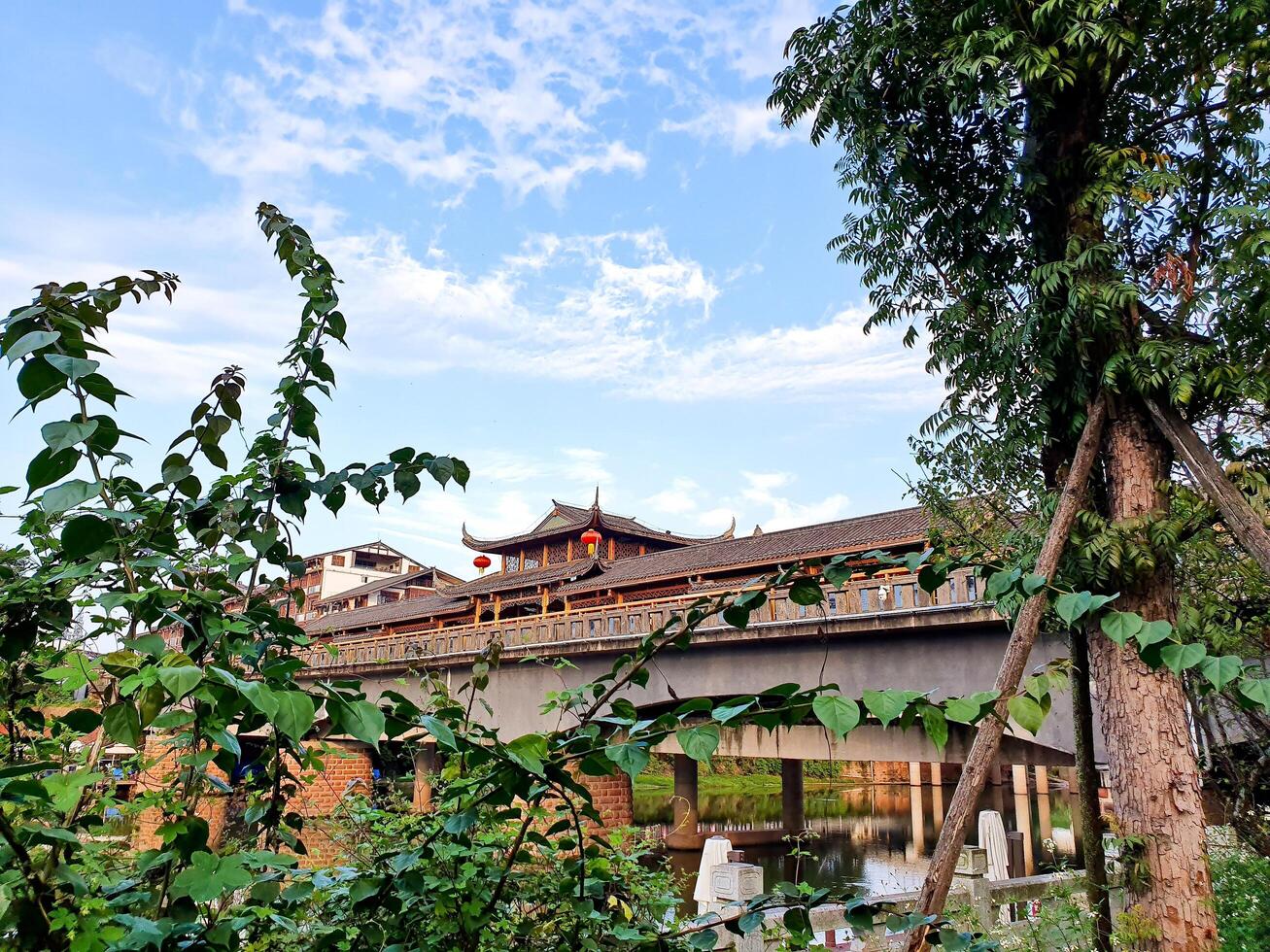 China, LeShan, 01.01.2025 a bridge over a river with a clock tower in the background photo