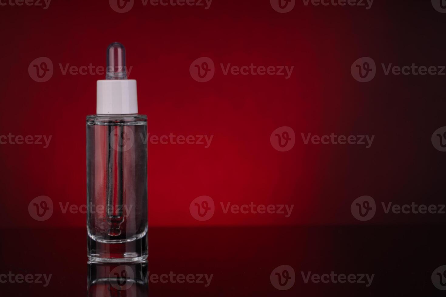 Glass Dropper Bottle with Empty Space for Text on Red Background photo