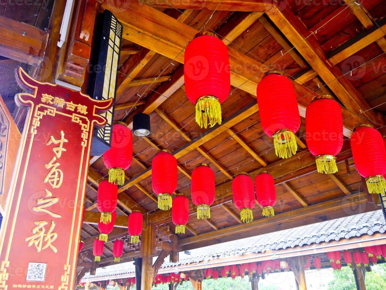 a group of red lanterns hanging from a roof photo