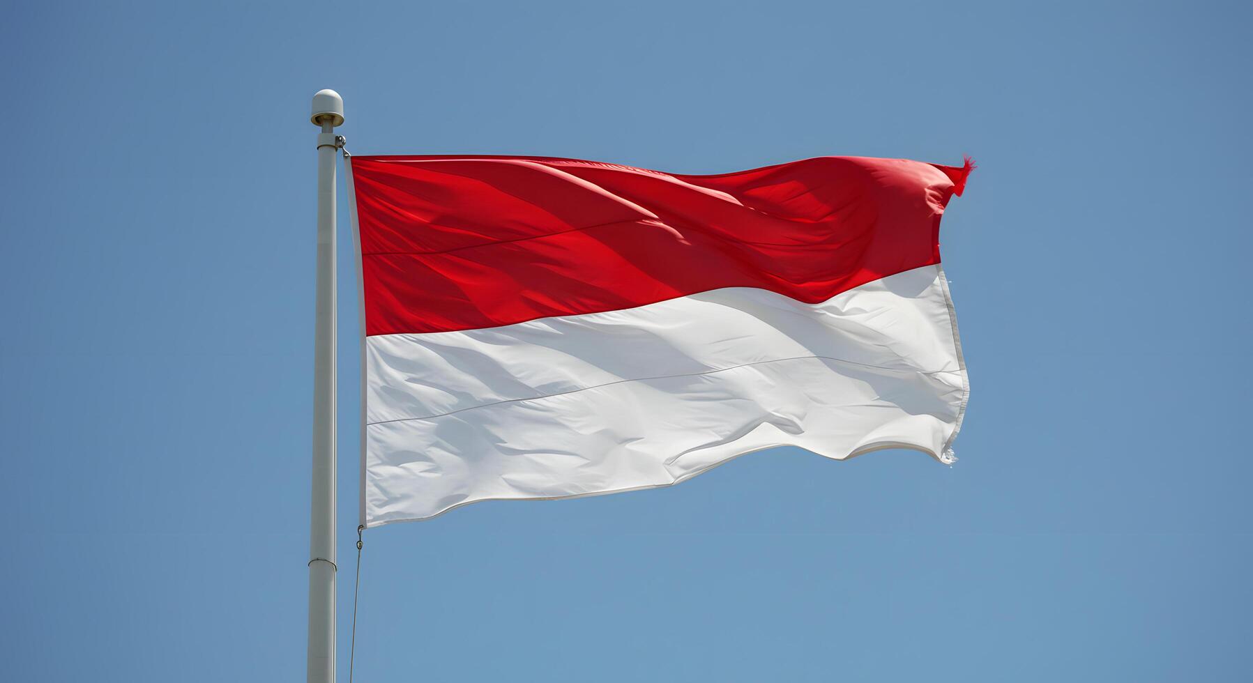 Indonesian Flag Waving Proudly Under a Clear Blue Sky A Symbol of National Identity and Unity photo