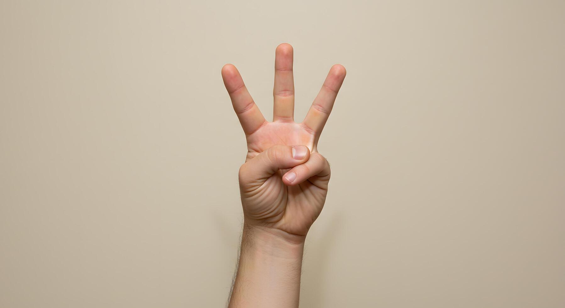 A Close Up Image of a Hand Showing the Number Three Against a Beige Background Simple Gesture Photography photo