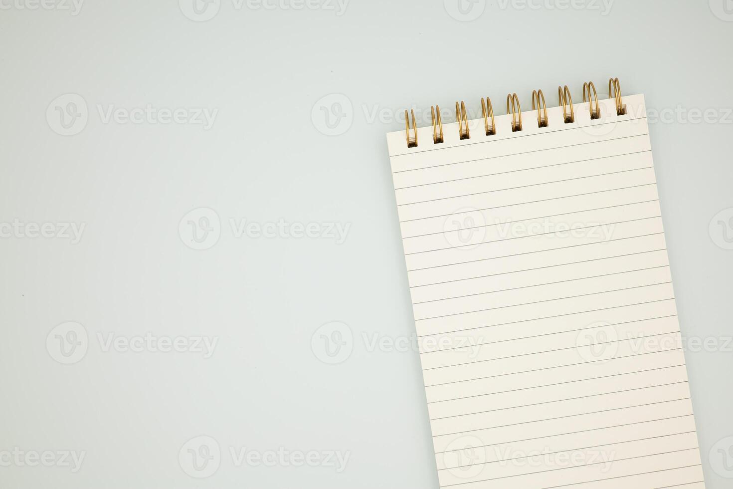 Spiral notepad with blank lined pages on light background photo