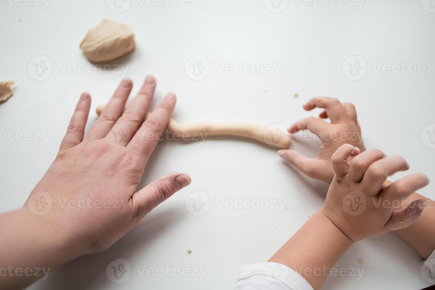 Hands shaping dough. Caucasian adult and child baking together photo