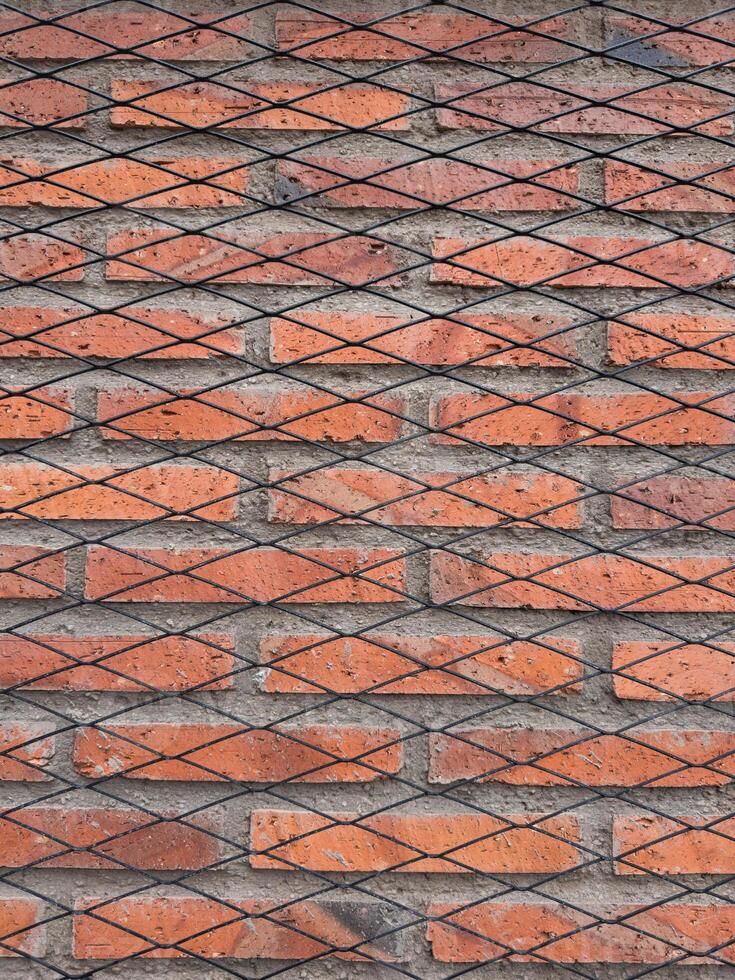 Textured red brick wall with black diagonal patterns for background design photo