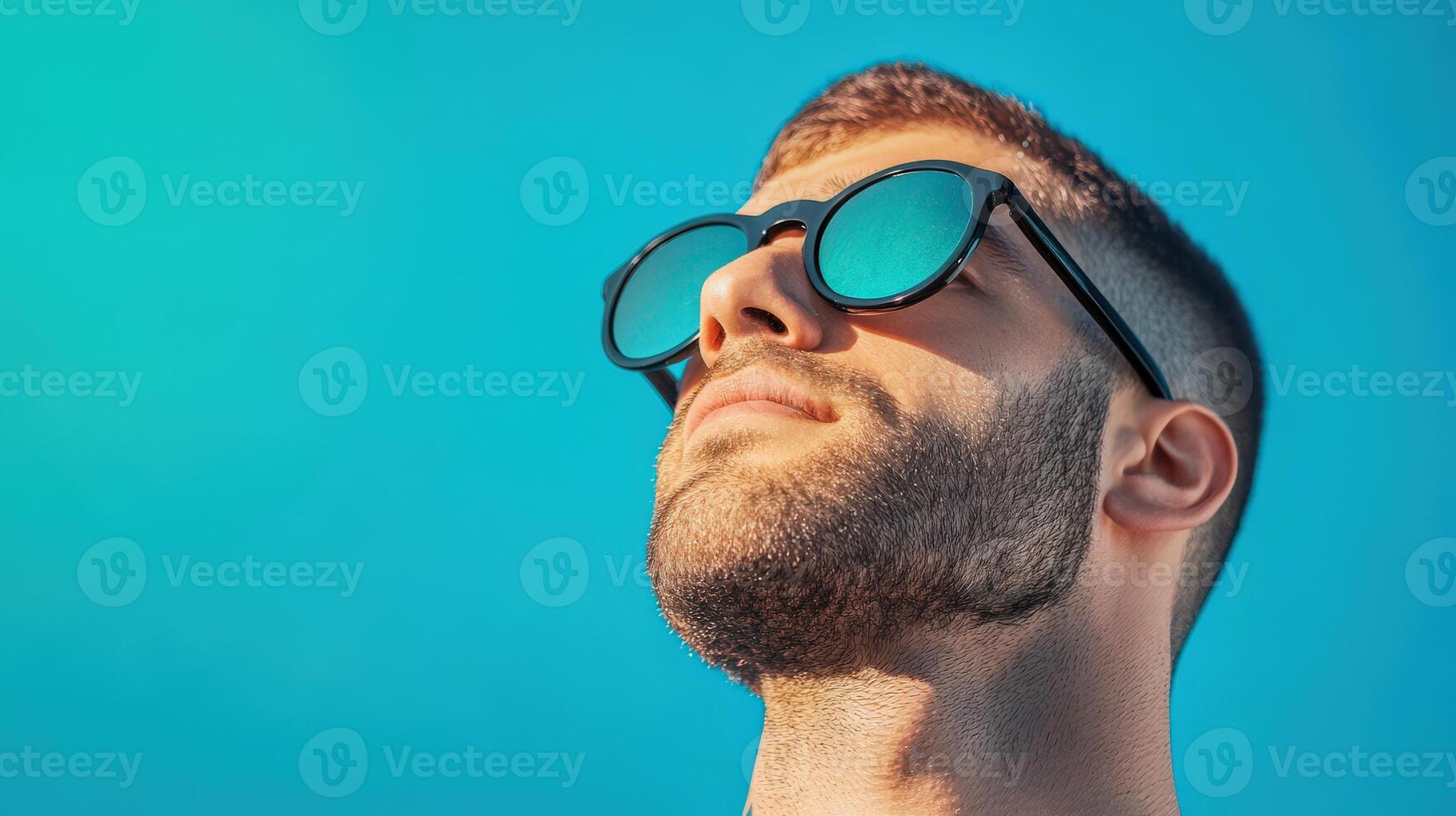 Man wearing sunglasses looks towards the sun photo