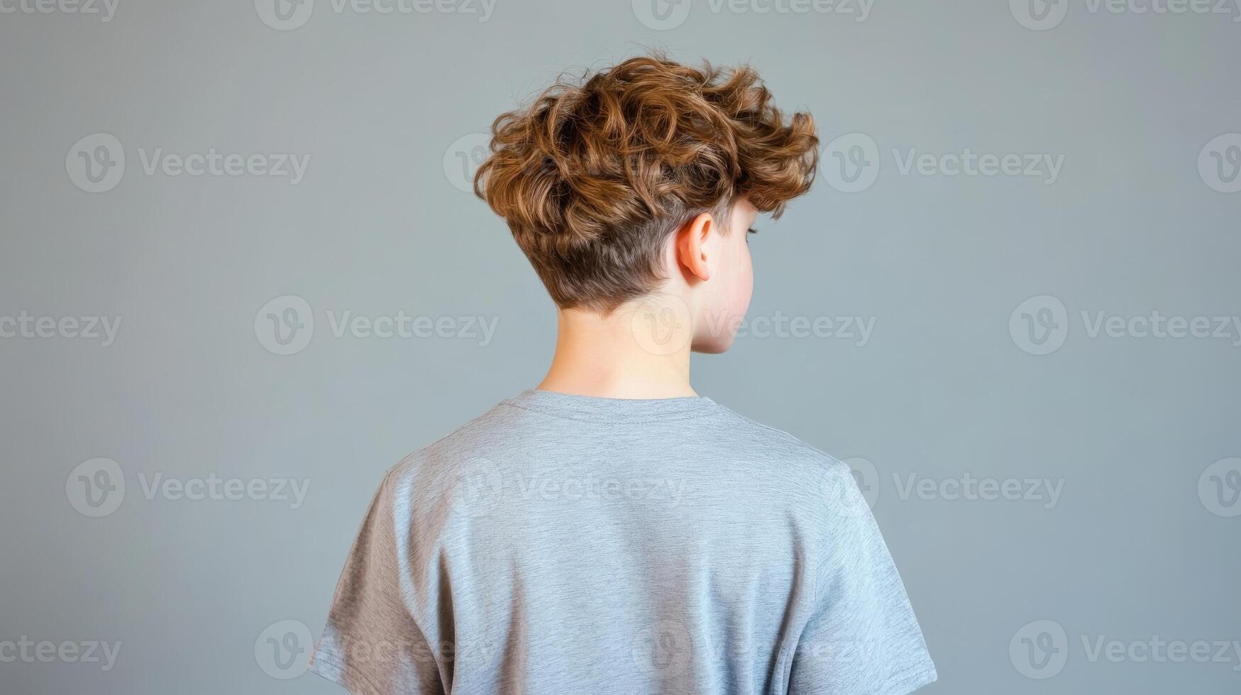 Young Boy With Curly Brown Hair Wearing Grey Shirt photo