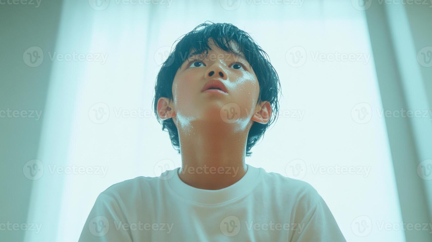 Sweaty Boy Looking Upwards Towards Light photo
