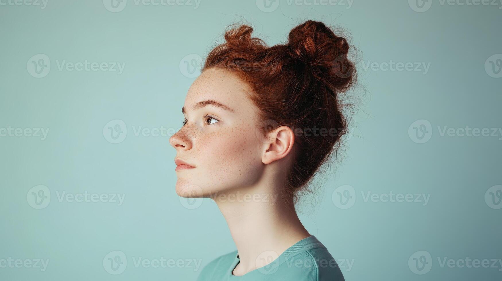 Red haired girl profile view with messy bun photo