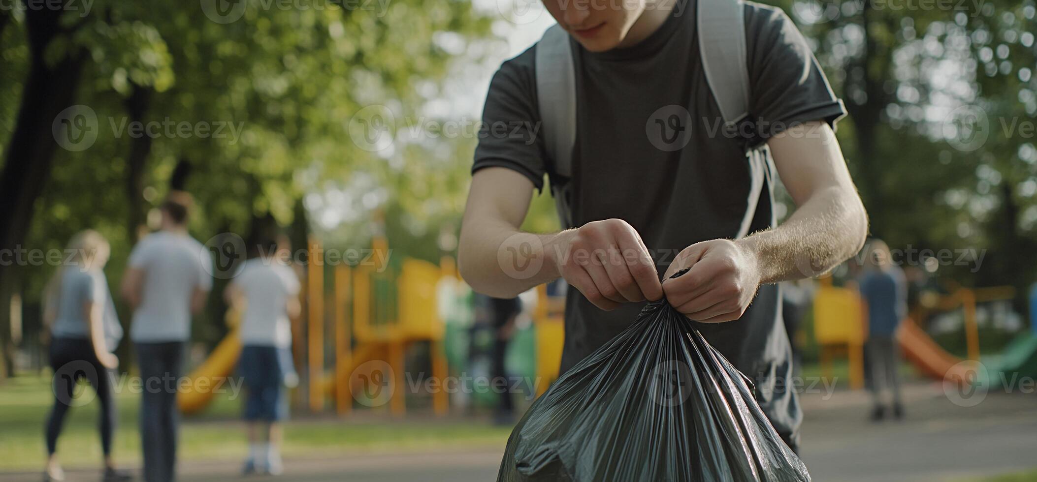 A man is picking up trash in a park photo