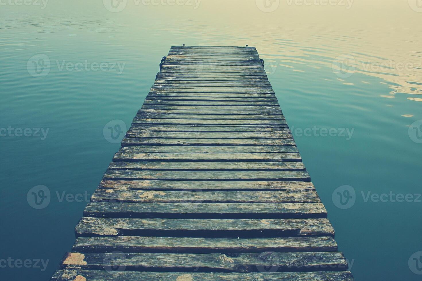 Weathered Wooden Dock Over Calm Blue Water with Tranquil Horizon for Peaceful Nature Scene photo