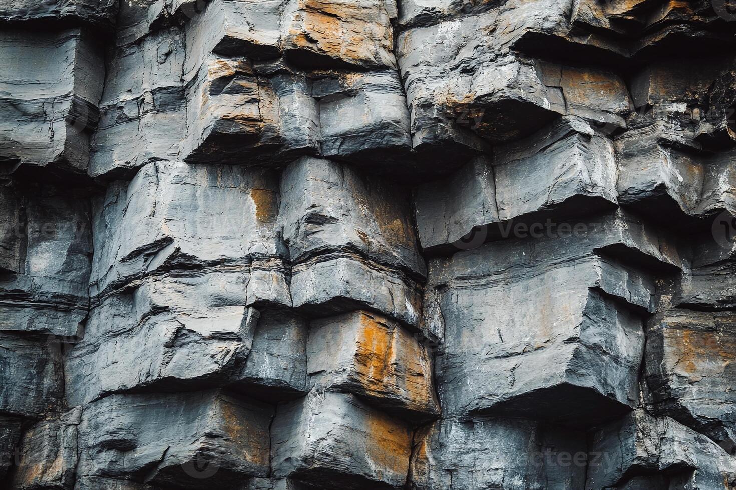 Natural Layered Rock Formation with Textured Gray and Orange Stone Surface in Cliff Landscape photo