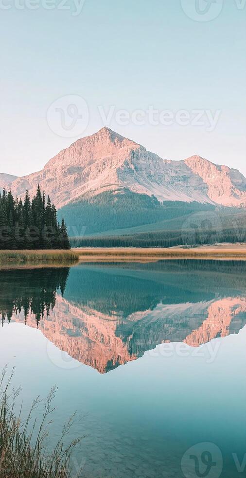 Majestic Mountain Reflecting in Calm Lake with Pine Forest Under Clear Blue Sky at Sunrise photo