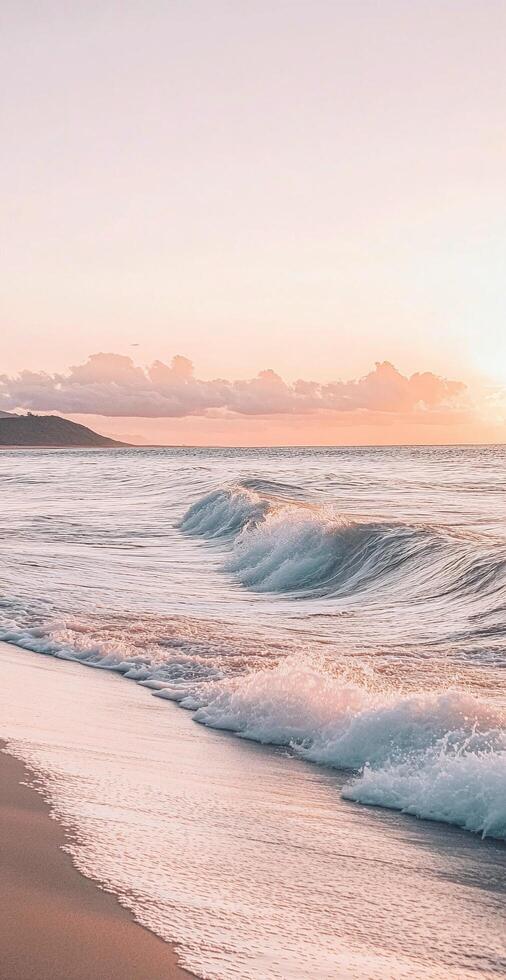 Serene Ocean Waves on Sandy Beach with Pastel Pink Sunset Sky and Gentle Clouds in the Background photo