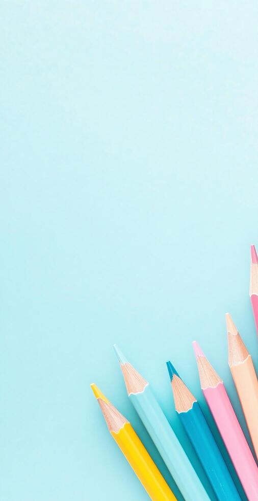 Bright Colored Pencils Arranged on Light Blue Background for Education and Creative Projects photo