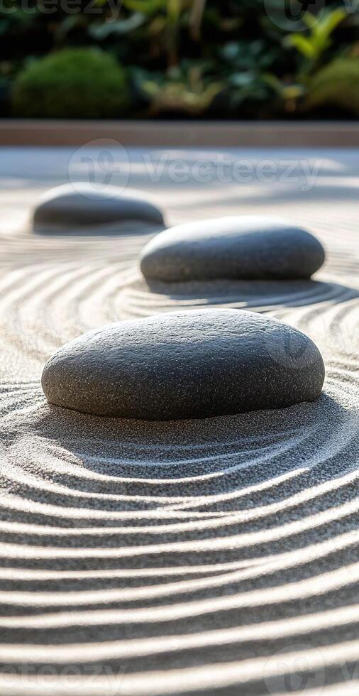 Smooth Gray Zen Stones Resting on Sand with Curved Raked Patterns in Tranquil Garden Setting photo