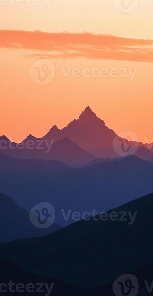 Silhouetted Mountain Peaks at Sunset with Vibrant Orange and Blue Gradient Sky photo