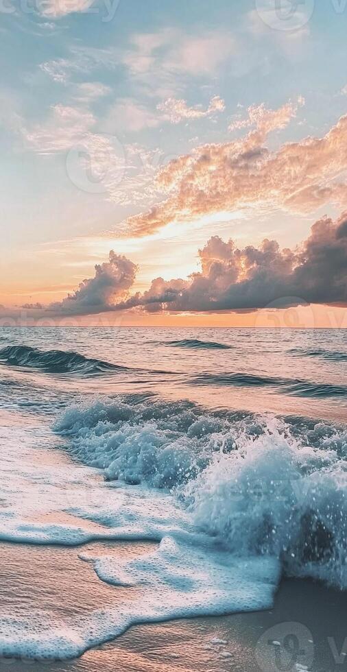 Calm Ocean Waves Splashing on Sandy Beach at Sunset with Vibrant Orange Blue Sky and Dramatic Clouds photo