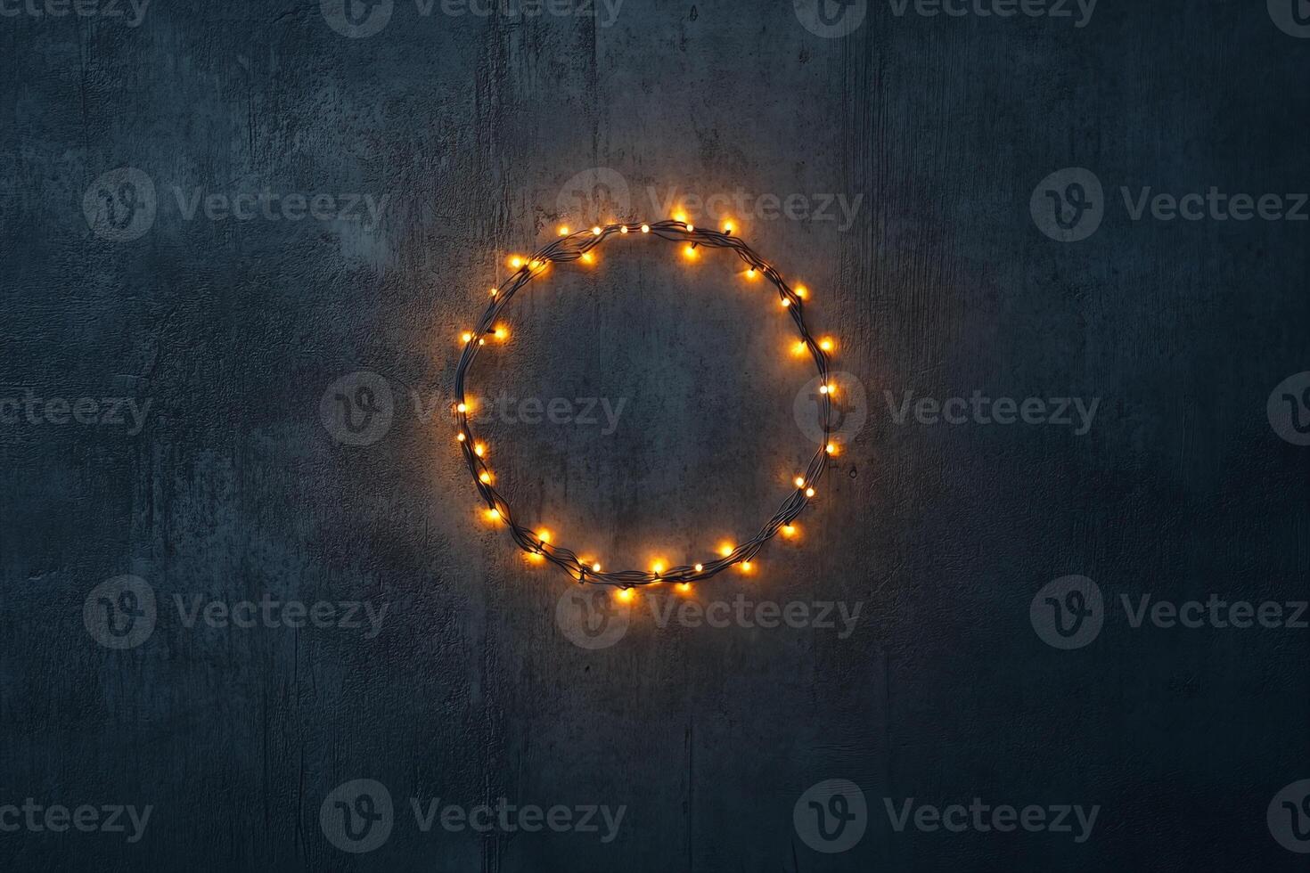 Circular Warm White String Lights Wreath on Dark Textured Concrete Wall Background for Festive Decor photo