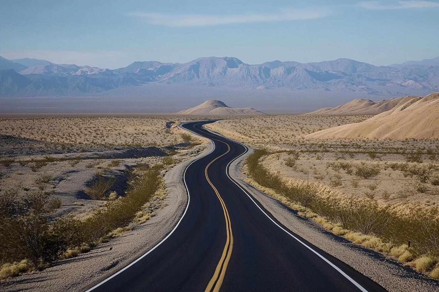 Winding Desert Road with Mountain View under Clear Blue Sky in Arid Landscape for Travel and Adventure photo