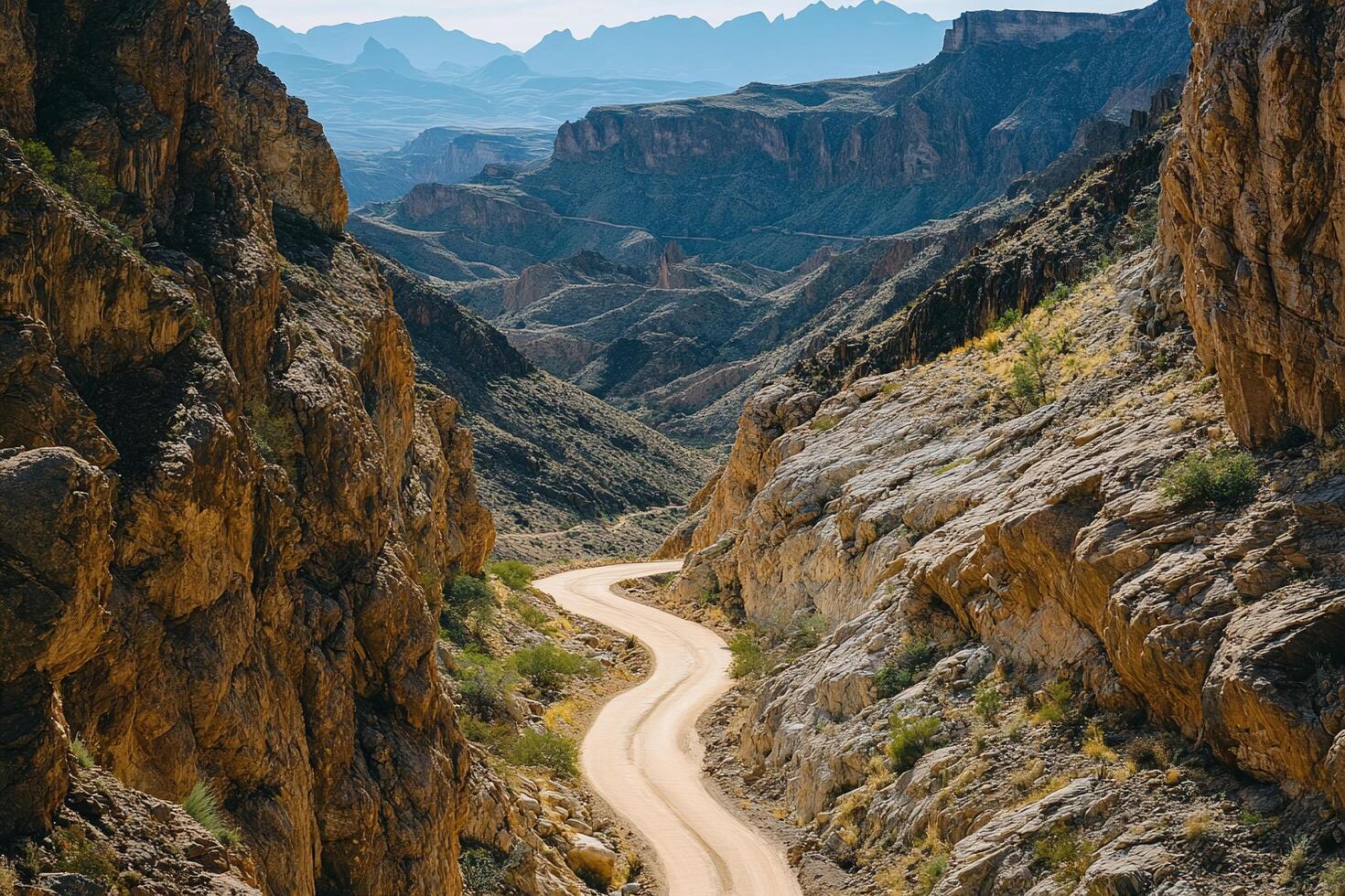 Winding Dirt Road Through Rocky Canyon Surrounded By Desert Landscape Under Clear Blue Sky photo