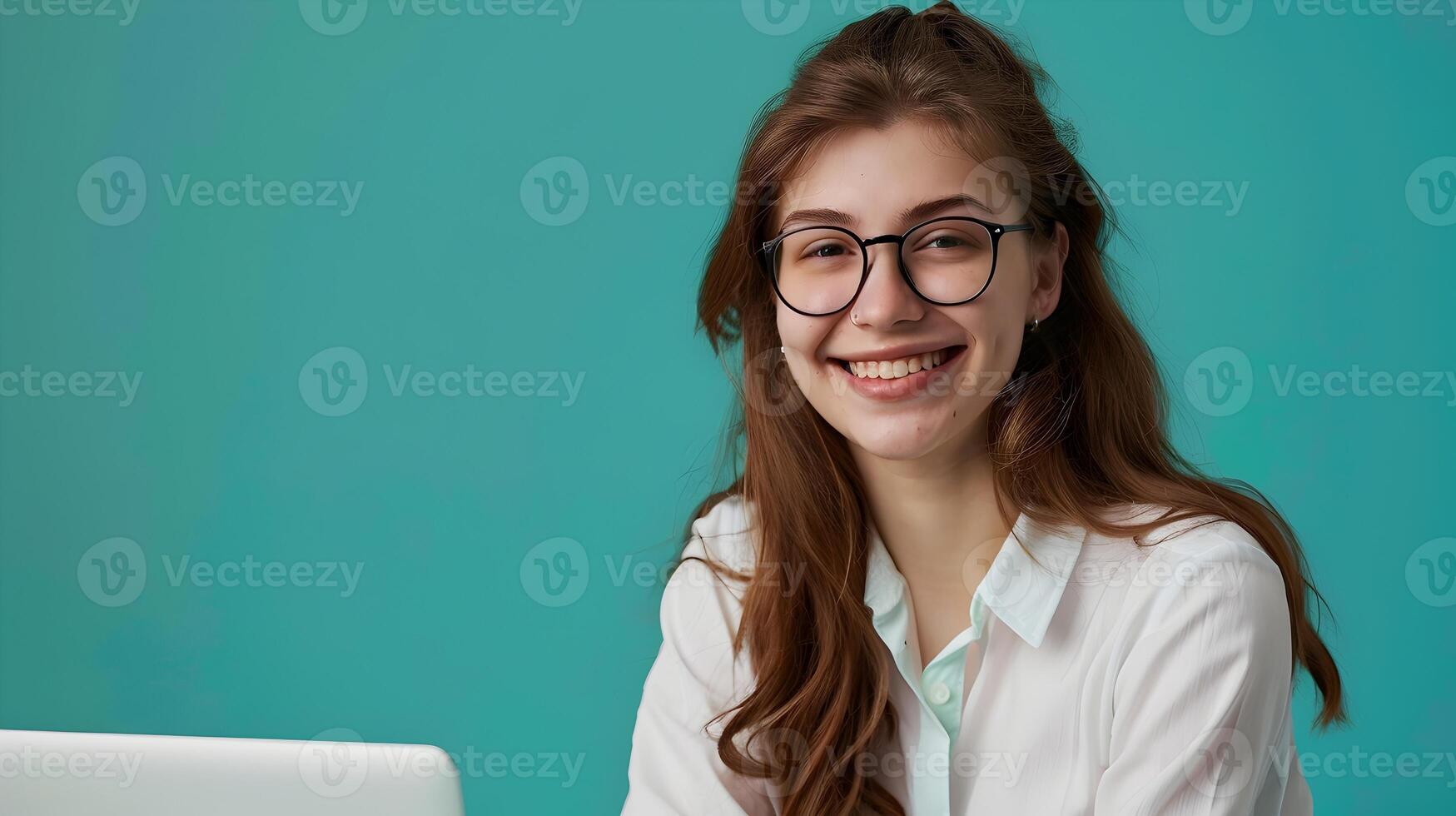 Young Female Communications Director Exuding Joy while Working on Laptop in Vibrant Office photo