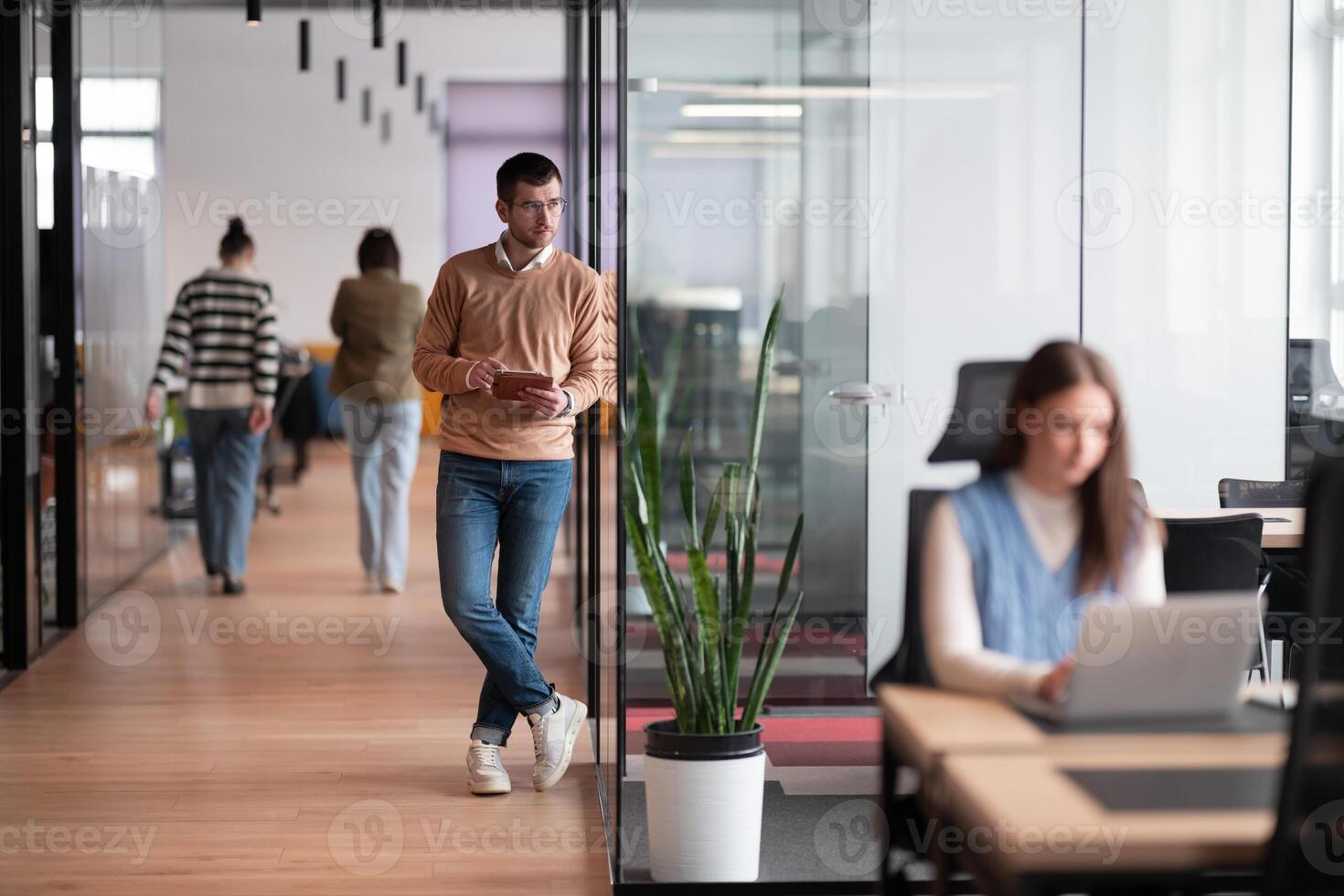 Senior bearded businessman, IT professional, trader, and crypto investor using a digital tablet in a modern coworking space. Tech-savvy professional working in an open office startup environment photo