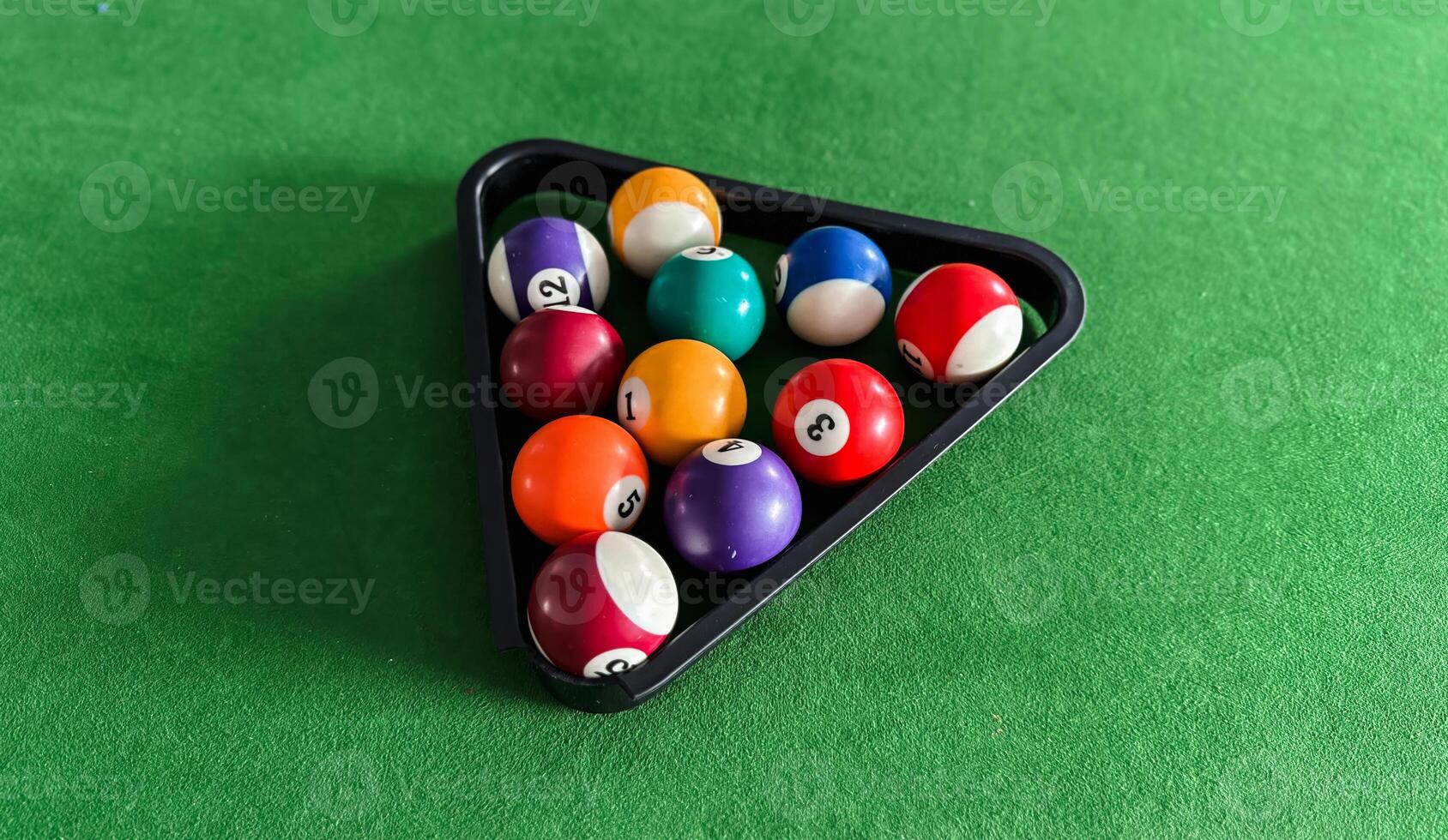 A black triangular tray with nine balls on it. The balls are numbered 1 through 9. photo